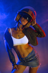 Fototapeta na wymiar girl in a helmet. Neon lighting.