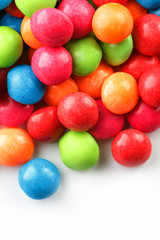 A rainbow of color from multicolored candies close-up, multi-colored glaze dragee on a white background
