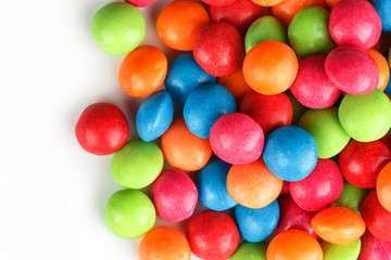 A rainbow of color from multicolored candies close-up, multi-colored glaze dragee on a white background
