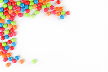 A rainbow of color from multicolored candies close-up, multi-colored glaze dragee on a white background