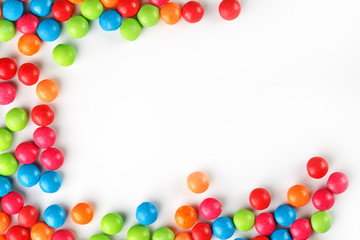 A rainbow of color from multicolored candies close-up, multi-colored glaze dragee on a white background