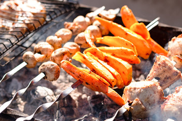 Carrots, mushrooms and meat grill closeup with smoke