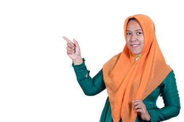 Portraits of young Asian Muslim business women wearing hijab  pointing finger at copy space, isolated on white background