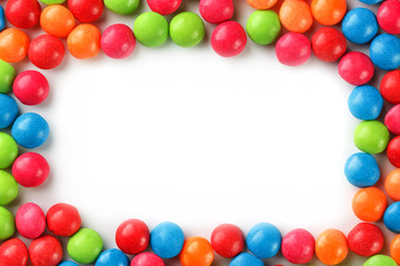 Frame of multi-colored candies close up. Rainbow colored dragee multicolored glaze on a white background