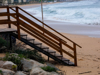 Escalera en la arena de la playa, esperando que el temporal amaine