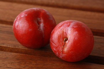 Delicious plums on wooden background