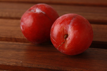 Delicious plums on wooden background