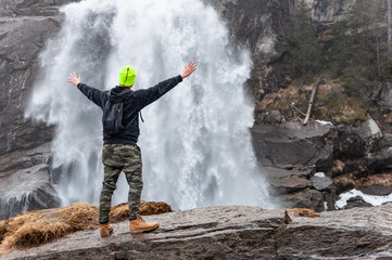 Obraz premium Man standing in front of waterfall