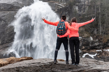 Young couple standing in front of waterfall