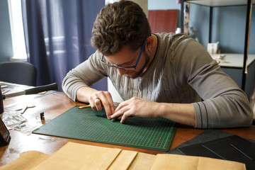 Leather craftsman working with natural leather. Handmade concept. Concept of small business to create leather products.