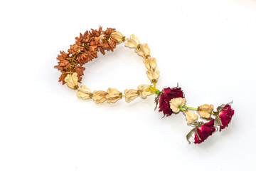 Old dried garland of flowers isolated against on white background.