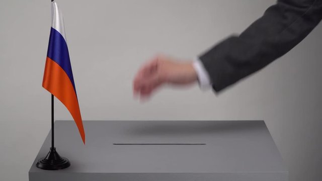 Ballot box with the national flag of Russia. Presidential and parliamentary elections. The voter throws the ballot in the ballot box.