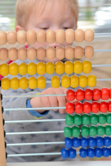 Child learning to count. Young boy using an abacus to learn maths