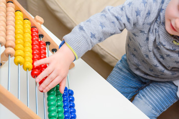 Child learning to count. Young boy using an abacus to learn maths