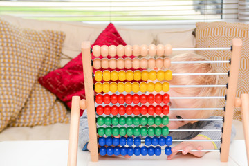 Child learning to count. Young boy using an abacus to learn maths
