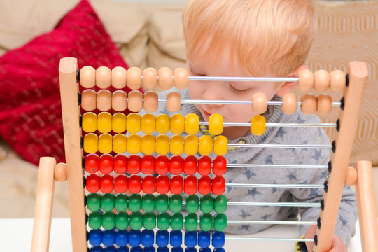 Child learning to count. Young boy using an abacus to learn maths