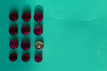 Buttons laid out in a row on a turquoise background. In the style of flat lay.
