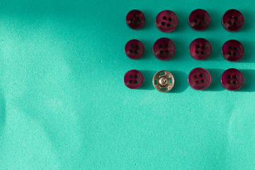 Buttons laid out in a row on a turquoise background. In the style of flat lay.