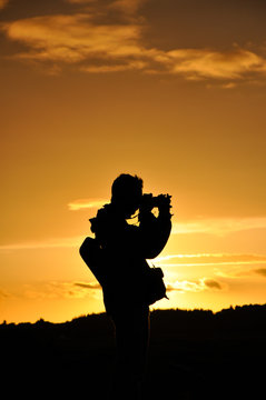 Silhouette of photographer against setting sun