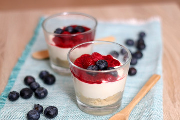 Simple no-bake raspberry cheesecake in a glass. Decorated with blueberries. Selective focus.