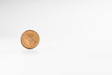Dollar coin rotating on white background, concept of American economy.