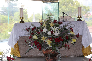 altar para celebración de misa católica con flores y cirio