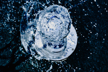 Water jet going up towards the camera, blue tones, background for hydrological concept.
