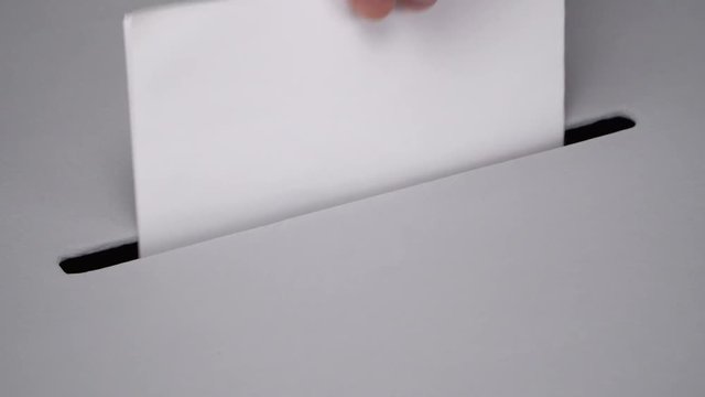 Close-up gray ballot box. Presidential and parliamentary elections. The voter throws the ballot into the ballot box.