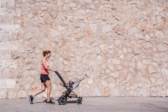 Woman, Mother Doing Fitness Pushing The Baby Stroller.