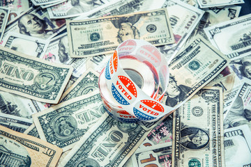 I vote Today stickers on a pile of American dollar bills, political election concept of economy and...