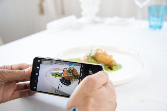 Food Photographer shooting food on phone's camera. Photo of food on camera display while shooting - Immagine