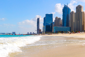 Naklejka premium Beach and skyscrapers at Jumeirah beach in Dubai marina and sunbeds.UAE