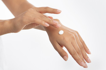 Cosmetics concept. Woman applying hand cream, white background,
