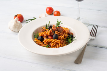Piatto di fusilli con sugo di salsiccia e olive nere