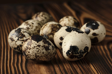 Front view of quail eggs on a wooden table of burnt wood