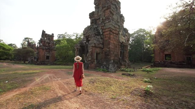 Woman is exploring ruins of Prasat Suor Prat, a series of twelve towers in Angkor Wat complex, made from rugged laterite and sandstone. Cambodia