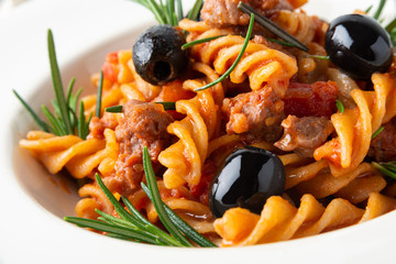 Piatto di fusilli con sugo di salsiccia e olive nere