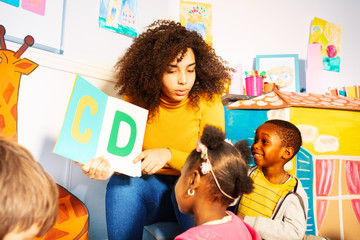 Kids learn alphabet in nursery school with teacher
