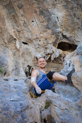 Fototapeta na wymiar Young man rock climbing on karst limestone white mountain in Thailand