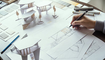 architect design working drawing sketch plans blueprints and making architectural construction model in architect studio