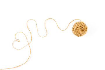 unwound ball of thread, a thread forms a heart on a white background