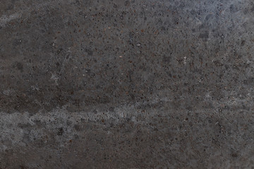 Smooth reinforced concrete surface of gray color interspersed with rubble.