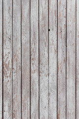 A whitewashed wooden surface worn out due to weather. Planks painted white. The texture of the wooden board.