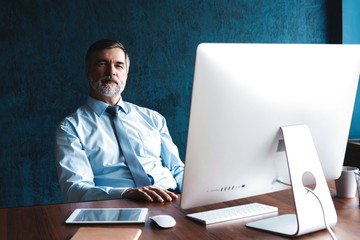 Mature Businessman Working On Computer In Office