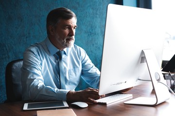 Mature Businessman Working On Computer In Office