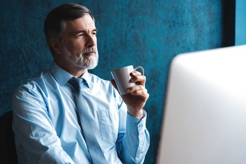 Mature Businessman Working On Computer In Office