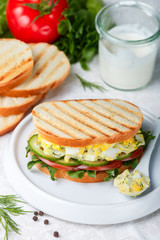 Sandwich with egg salad, lettuce, tomatoes, cucumbers and dill. Gourmet Breakfast. Selective focus