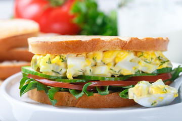 Sandwich with egg salad, lettuce, tomatoes, cucumbers and dill. Gourmet Breakfast. Selective focus