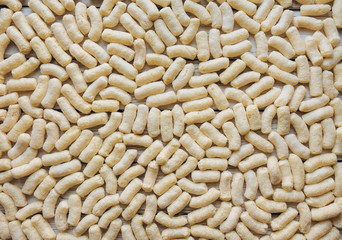 Background of yellow corn sticks. The view from the top. Texture of snacks.