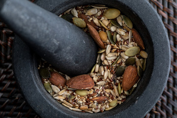 Close-up with mix of seeds and nuts. In stone mortar. Rustic appearance.